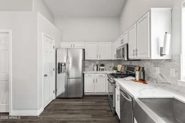 a kitchen with stainless steel appliances white cabinets and a sink