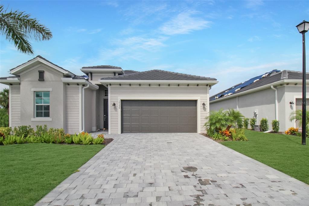 17335 Jadestone Court Venice, FL 34293 - Photo 2 of 54 a front view of a house with a garden and yard