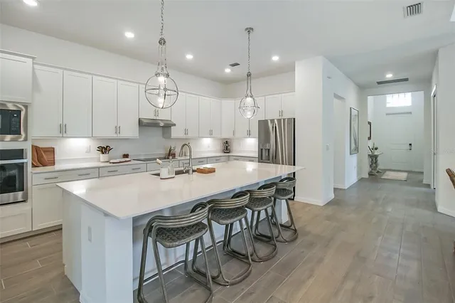 a kitchen with stainless steel appliances a refrigerator sink and cabinets