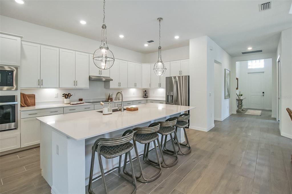 17335 Jadestone Court Venice, FL 34293 - Photo 26 of 54 a kitchen with stainless steel appliances a table chairs refrigerator and sink
