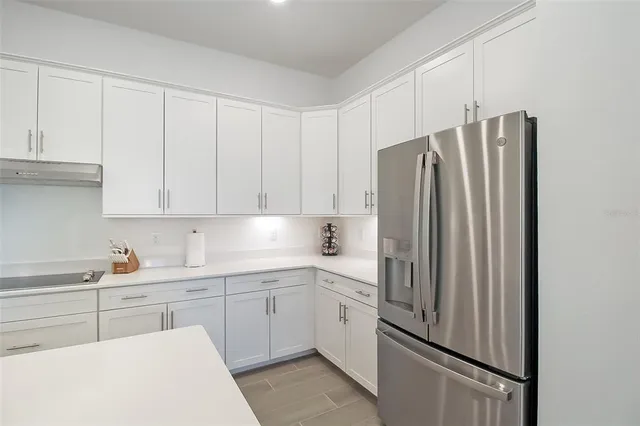 a kitchen with white cabinets and sink