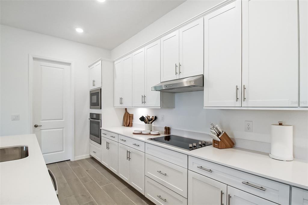 17335 Jadestone Court Venice, FL 34293 - Photo 28 of 54 a kitchen with white cabinets and sink