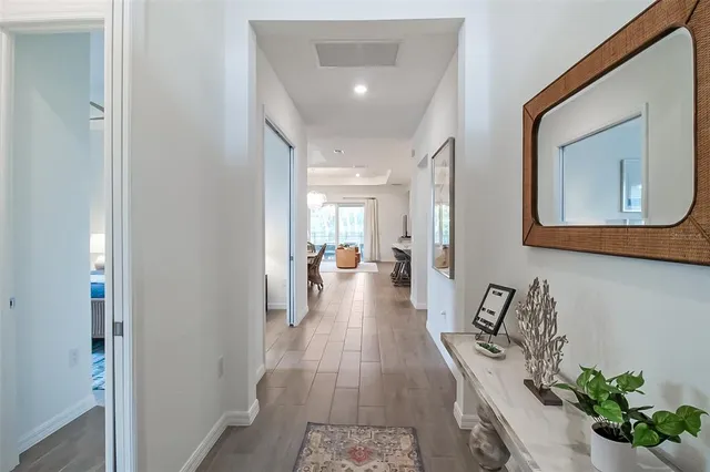 a hallway with a dining table a chandelier and a mirror