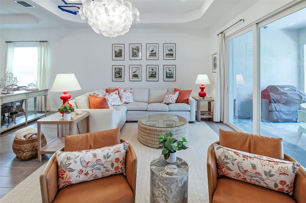 17335 Jadestone Court Venice, FL 34293 - Photo 32 of 54 a living room with furniture and a chandelier