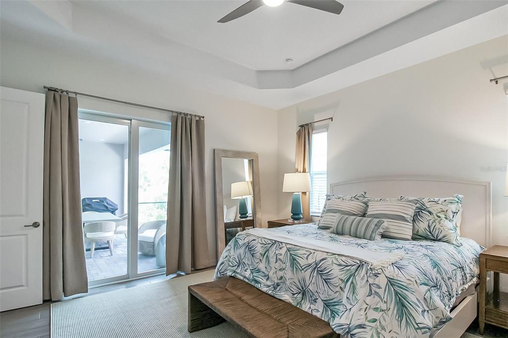 17335 Jadestone Court Venice, FL 34293 - Photo 38 of 54 a bedroom with a balcony a bed and a chandelier