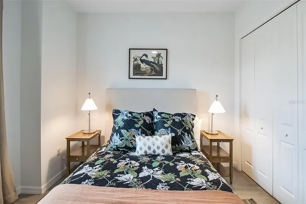 a bedroom with a bed and a mirror on the dresser