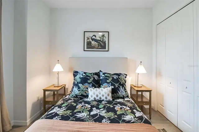 a bedroom with a bed and a mirror on the dresser