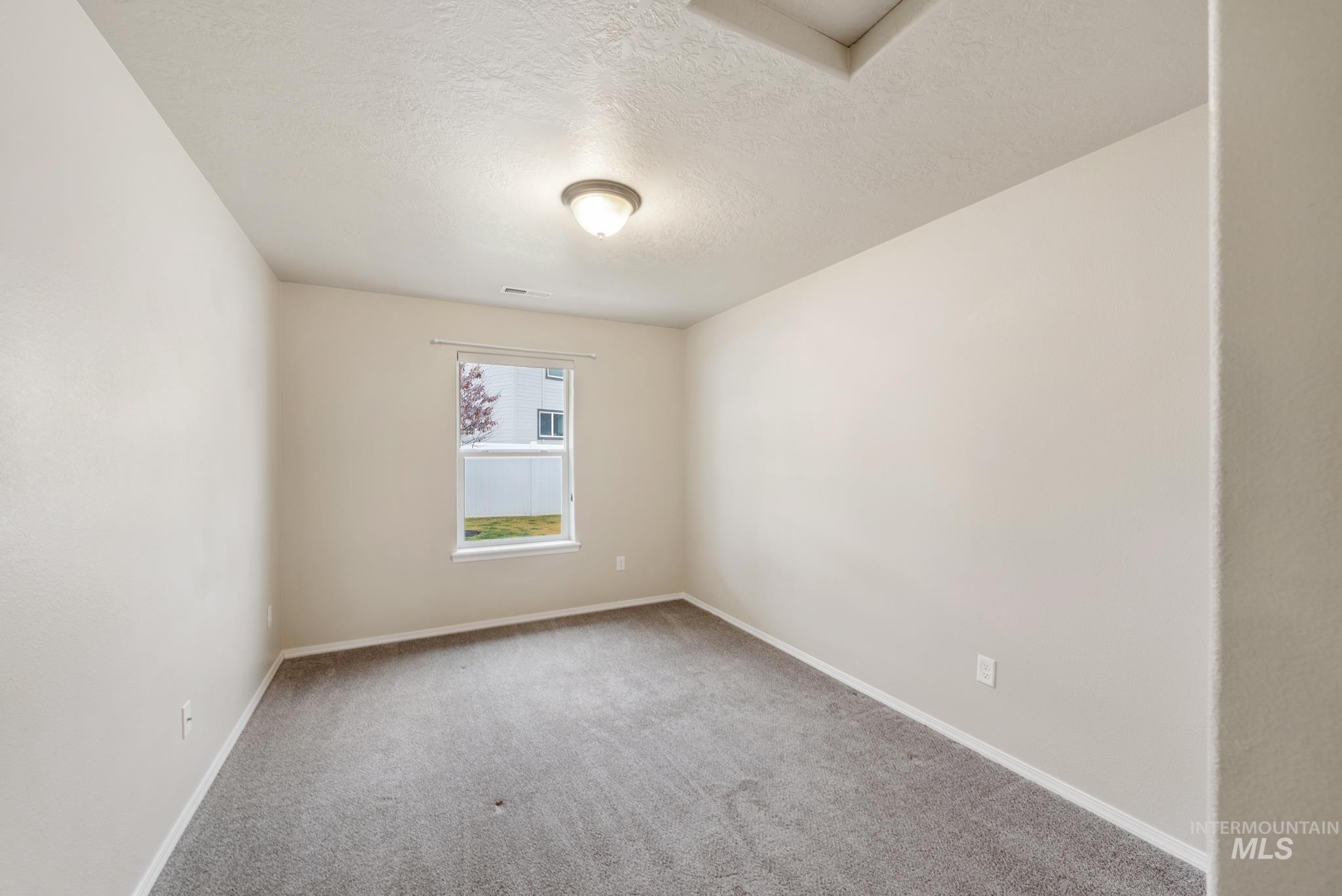 19081 Harley Way Caldwell, ID 83605 - Photo 17 of 35 Empty room with a textured ceiling and carpet