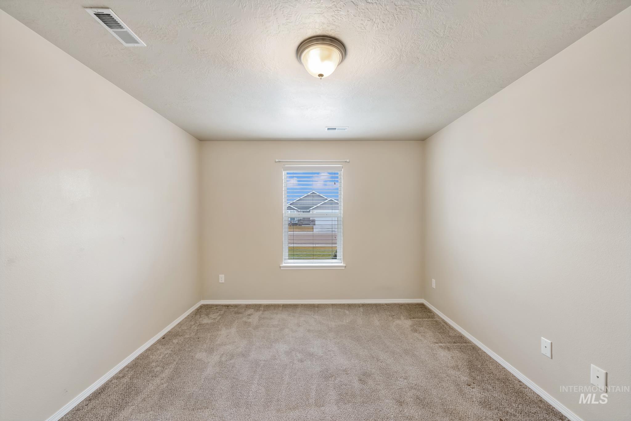 19081 Harley Way Caldwell, ID 83605 - Photo 21 of 35 Empty room with light carpet and a textured ceiling