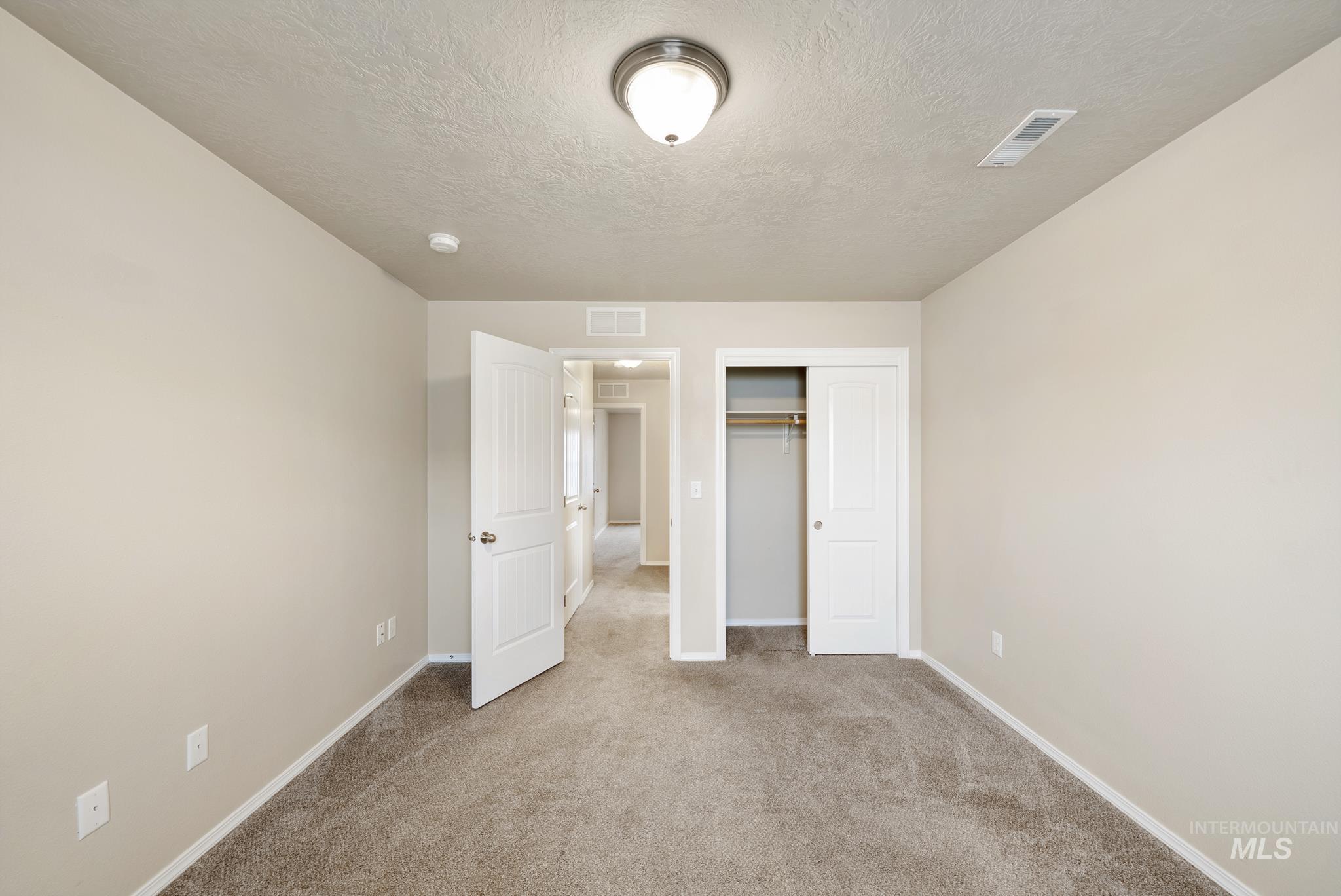 19081 Harley Way Caldwell, ID 83605 - Photo 22 of 35 Unfurnished bedroom featuring a textured ceiling, a closet, and carpet floors