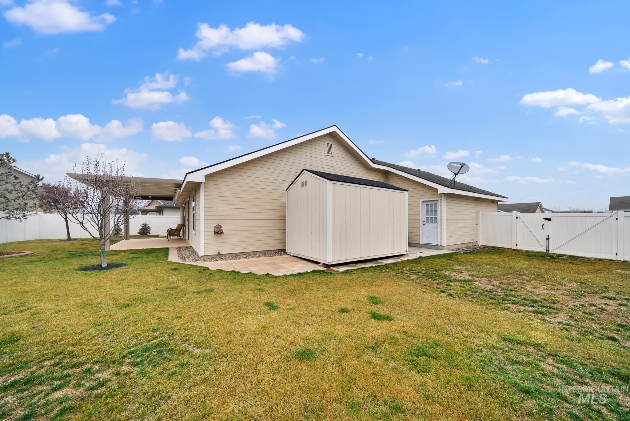 19081 Harley Way Caldwell, ID 83605 - Photo 26 of 35 Rear view of property with a gate, a fenced backyard, and a patio area