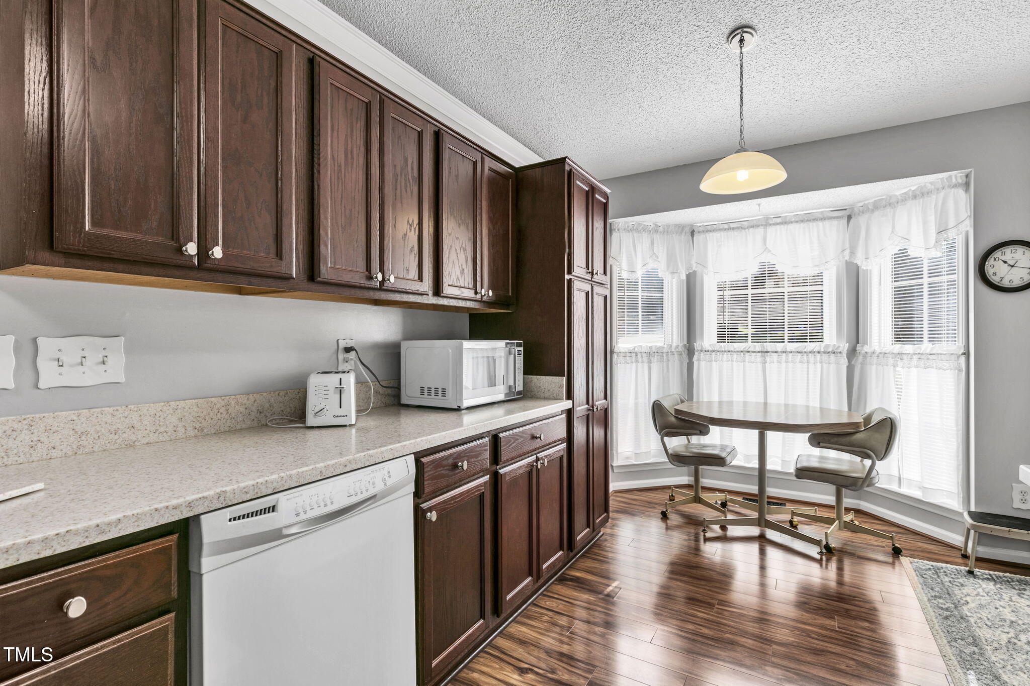 4317 Snow Goose Court Raleigh, NC 27616 - Photo 12 of 43 a kitchen with stainless steel appliances granite countertop a stove a sink dishwasher a dining table and chairs with wooden floor