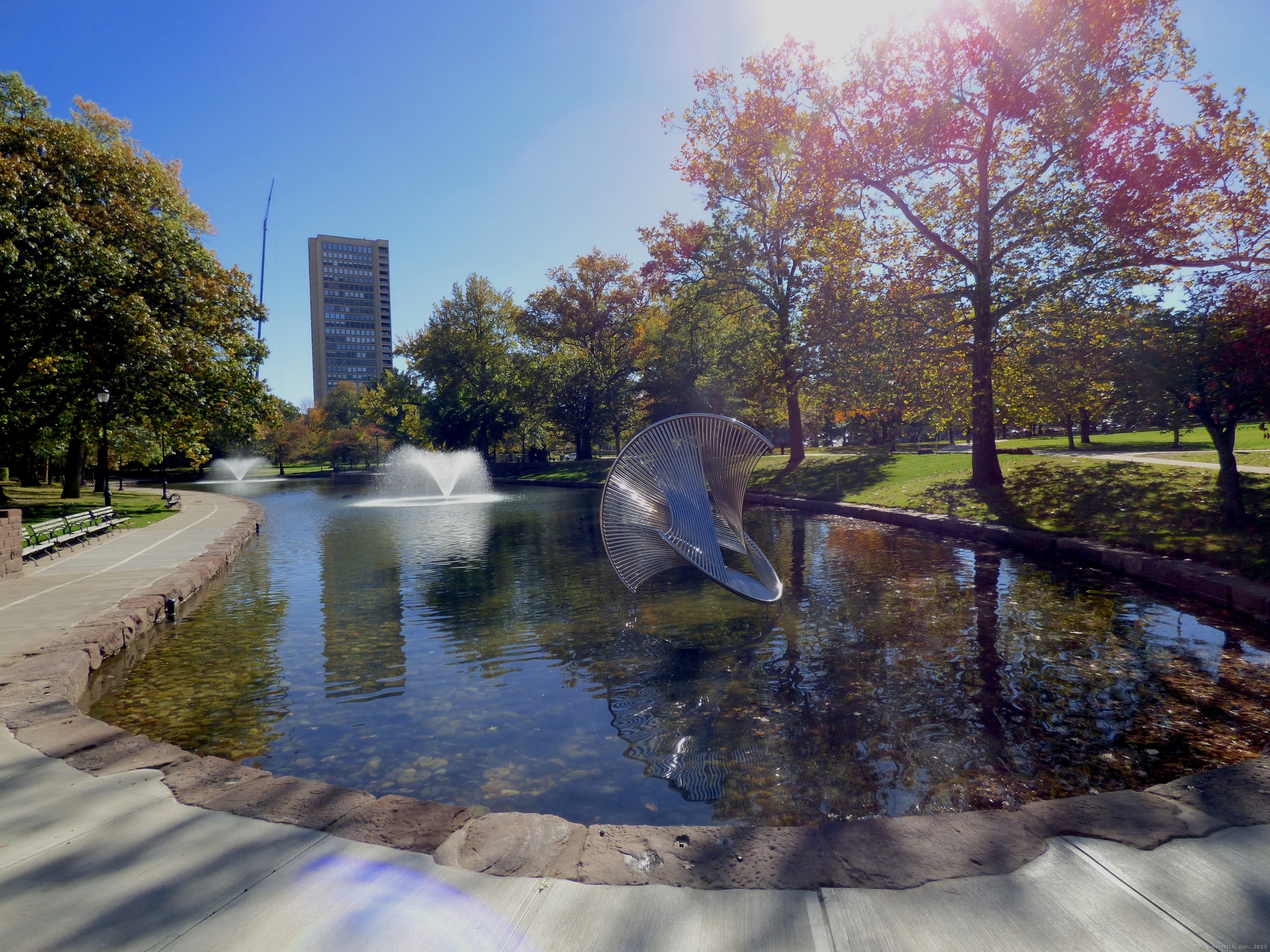 a view of a water fountain with large trees