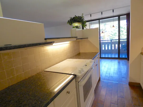 a view of a kitchen with a sink and wooden floor