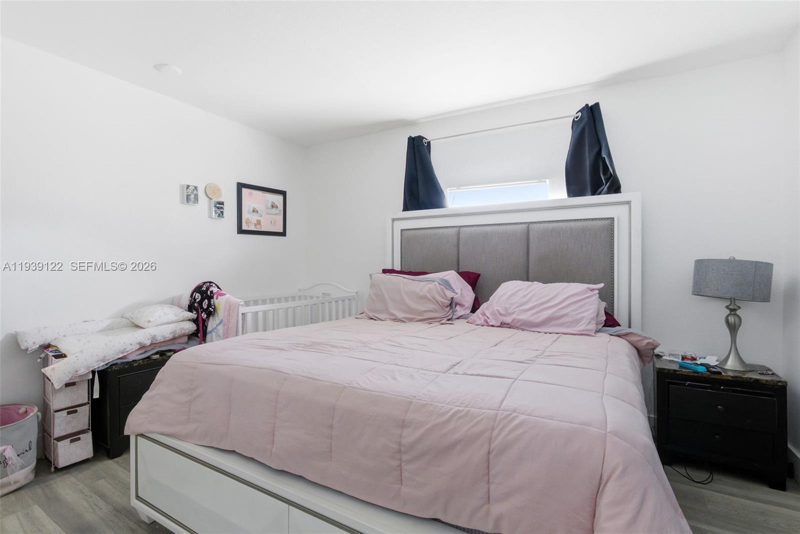 2142 Northwest 33rd Street Miami, FL 33142 - Photo 13 of 26 a bedroom with a bed and a lamp