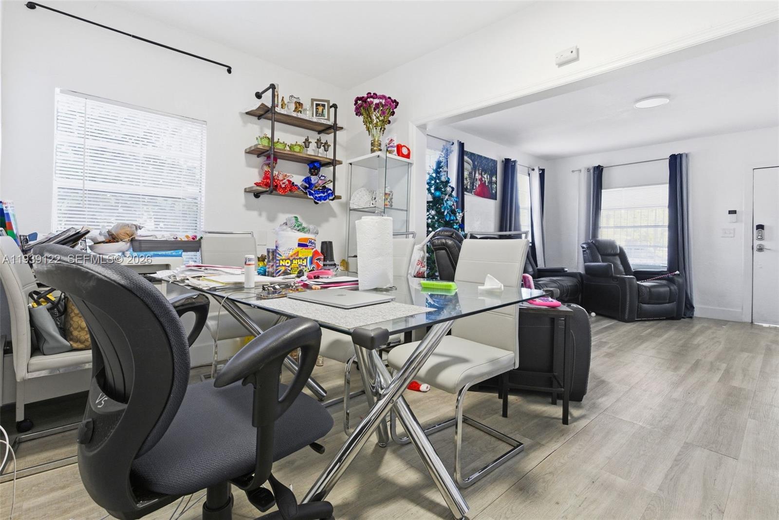 2142 Northwest 33rd Street Miami, FL 33142 - Photo 16 of 26 a view of a dining room with furniture a chandelier and wooden floor