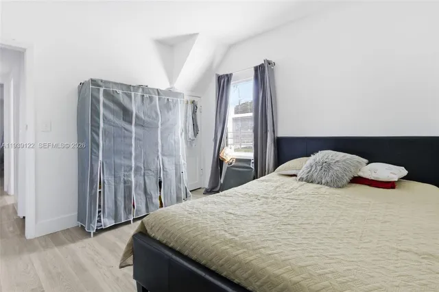 a bedroom with a bed and wooden floor