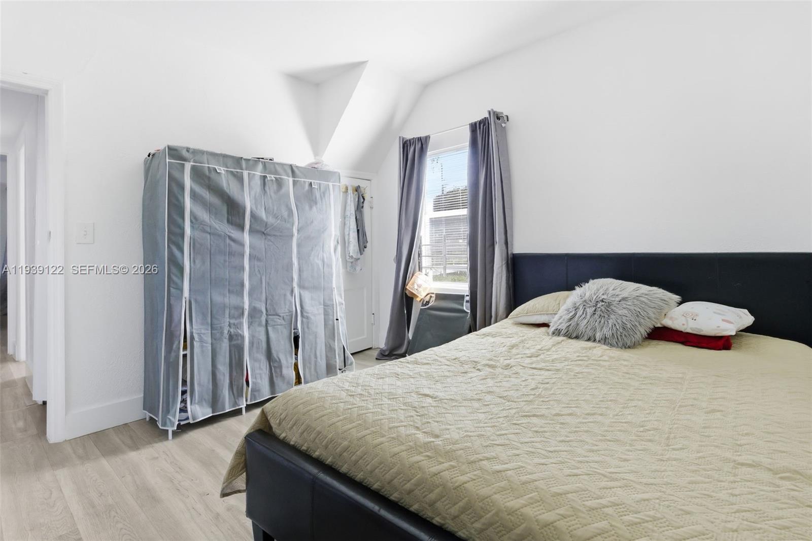 2142 Northwest 33rd Street Miami, FL 33142 - Photo 23 of 26 a bedroom with a bed and wooden floor