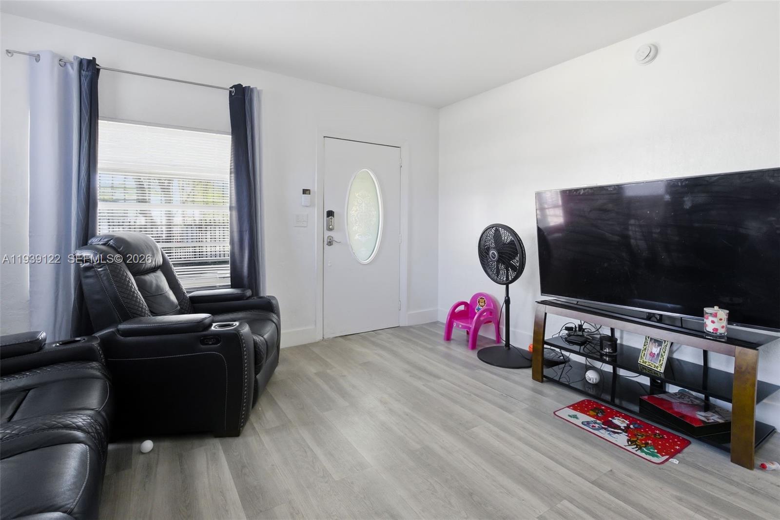 2142 Northwest 33rd Street Miami, FL 33142 - Photo 10 of 26 a living room with furniture flat screen tv and a window