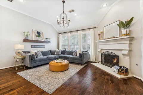 a living room with furniture a fireplace and a chandelier