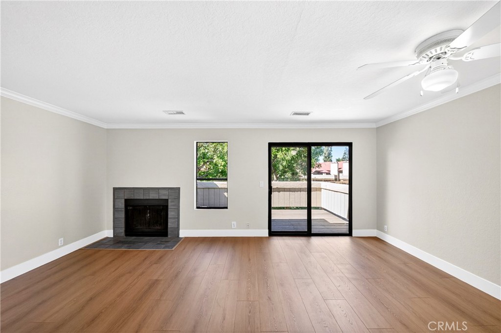 10151 Arrow Route, Unit 26 Rancho Cucamonga, CA 91730 - Photo 11 of 35 an empty room with windows and fireplace