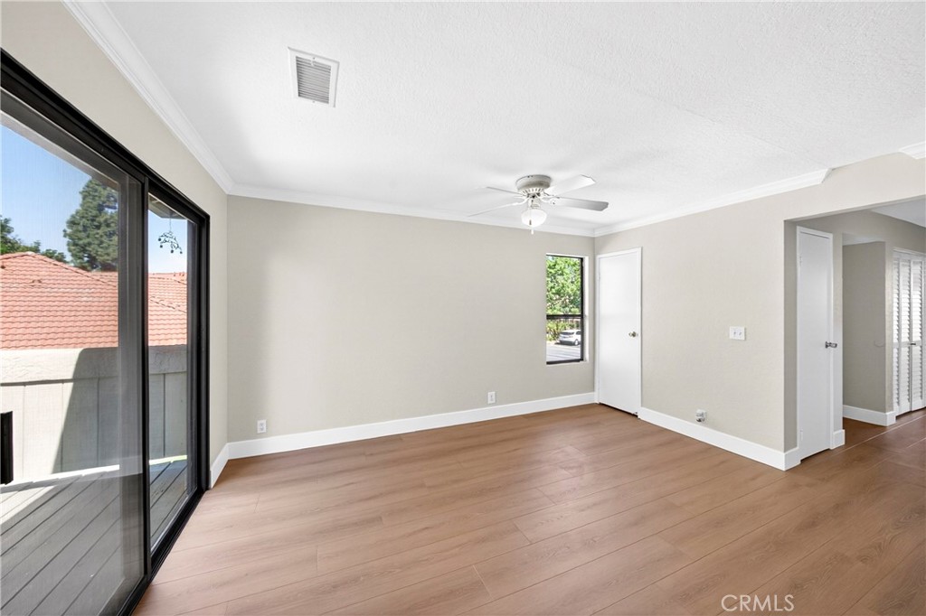 10151 Arrow Route, Unit 26 Rancho Cucamonga, CA 91730 - Photo 12 of 35 an empty room with wooden floor and windows