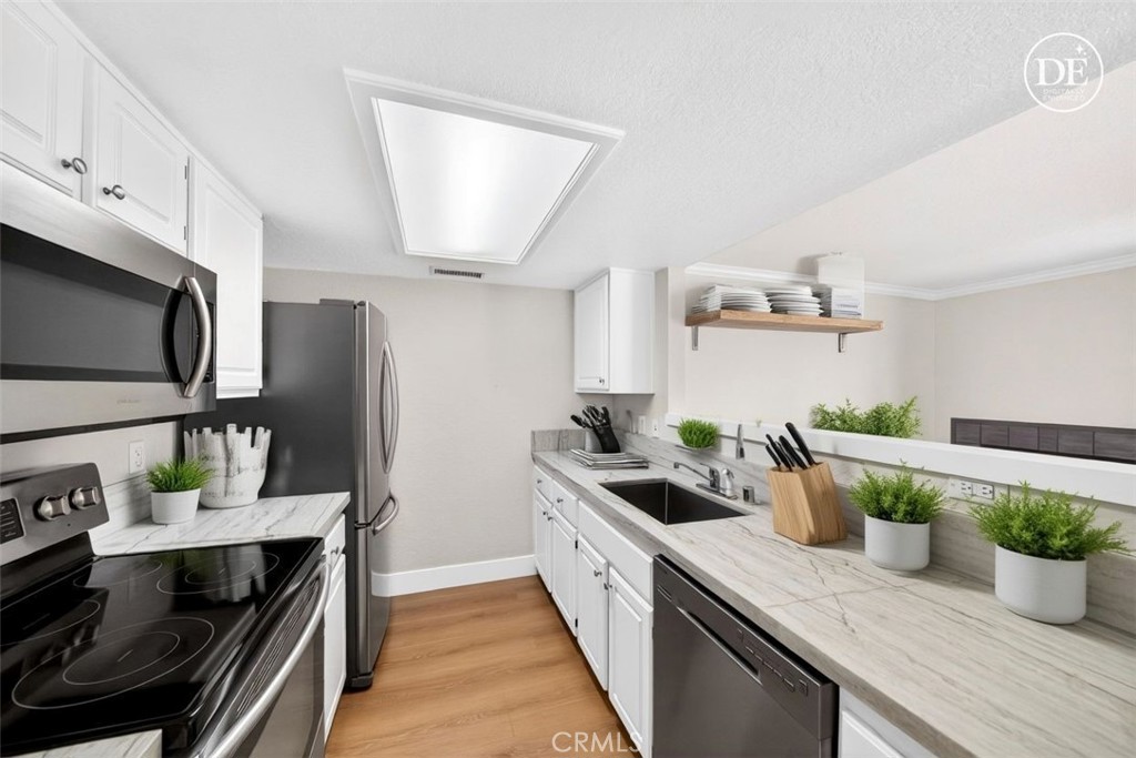 10151 Arrow Route, Unit 26 Rancho Cucamonga, CA 91730 - Photo 4 of 35 a kitchen with a stove and a microwave