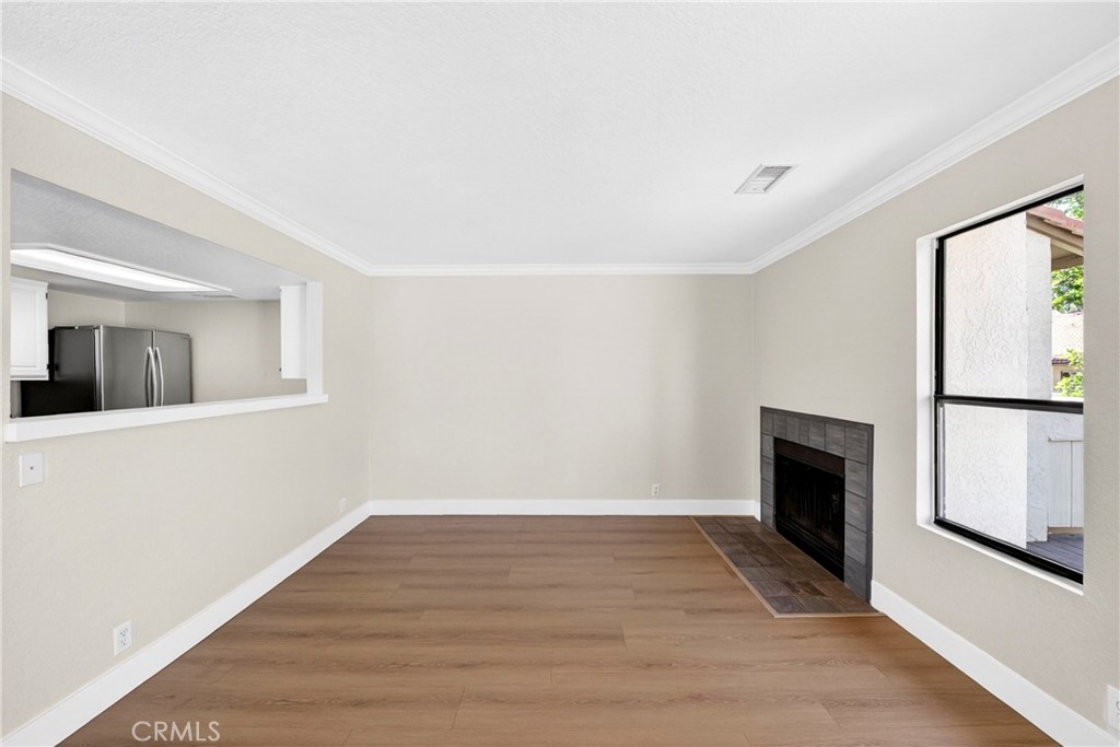 10151 Arrow Route, Unit 26 Rancho Cucamonga, CA 91730 - Photo 8 of 35 a view of an empty room with wooden floor and a window