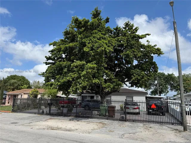 a front view of a house with a tree