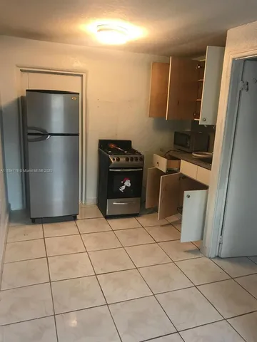 a kitchen with a refrigerator and a stove