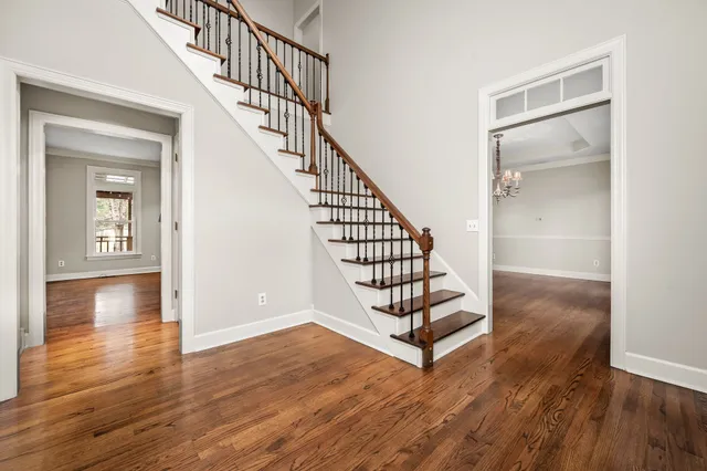 a view of an empty room with wooden floor fireplace and a window