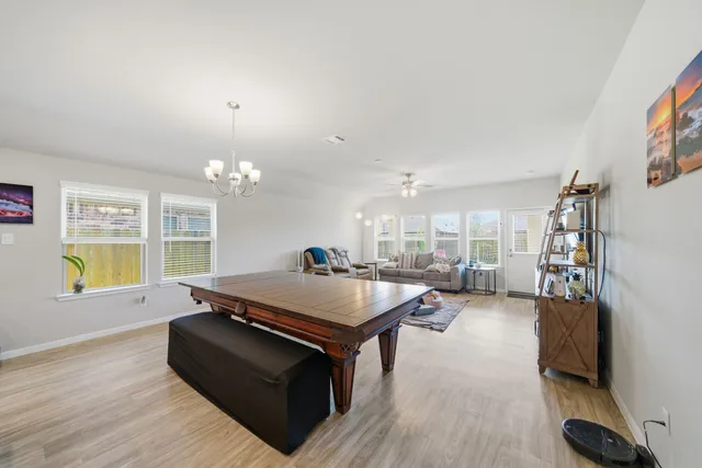 a living room with furniture a chandelier and a flat screen tv