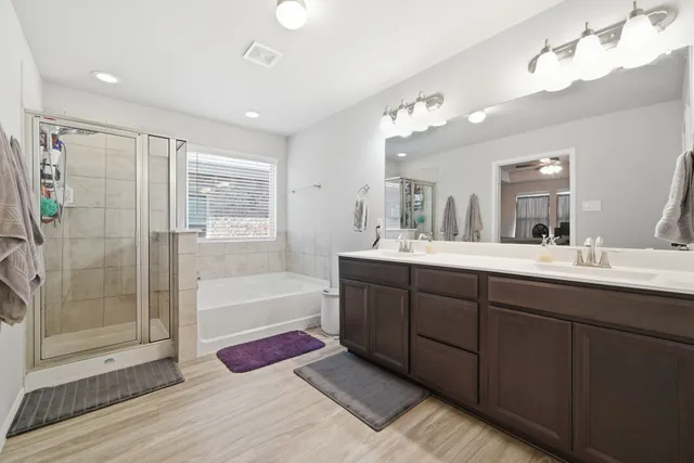 a bathroom with a tub sink shower and mirror