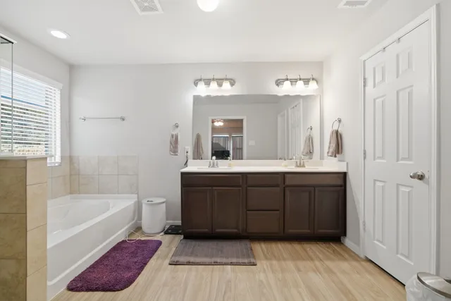 a bathroom with a tub sink and mirror