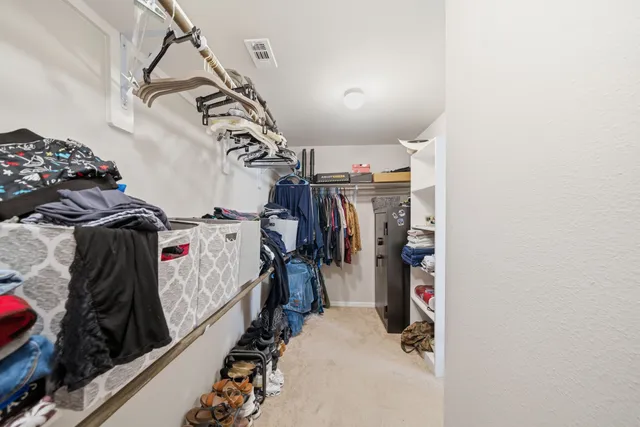 a view of walk in closet with clothes and shoes