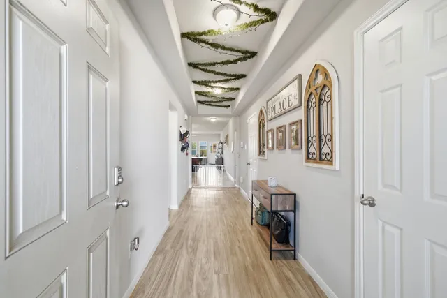 a view of a hallway with wooden floor and staircase