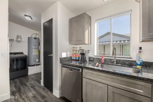 a kitchen with stainless steel appliances granite countertop a sink and a refrigerator