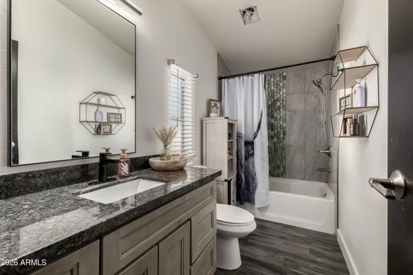 a bathroom with a granite countertop sink toilet and shower