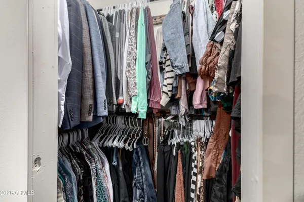 a view of a walk in closet with clothes