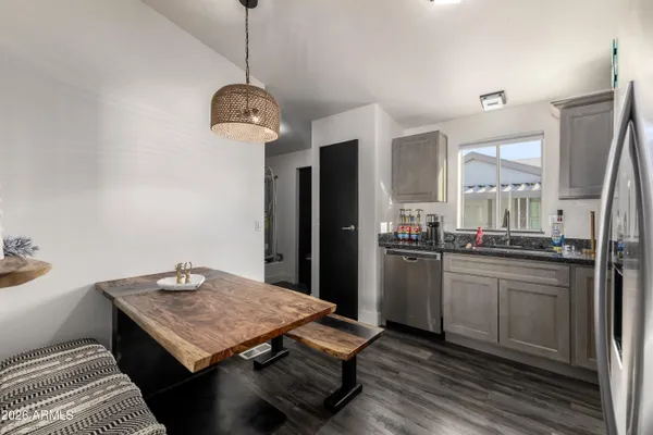 a kitchen with a sink a refrigerator and wooden floor
