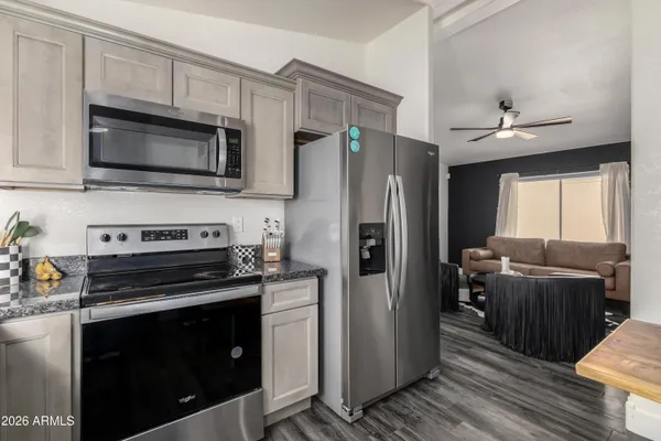 a kitchen with granite countertop a refrigerator stove and microwave