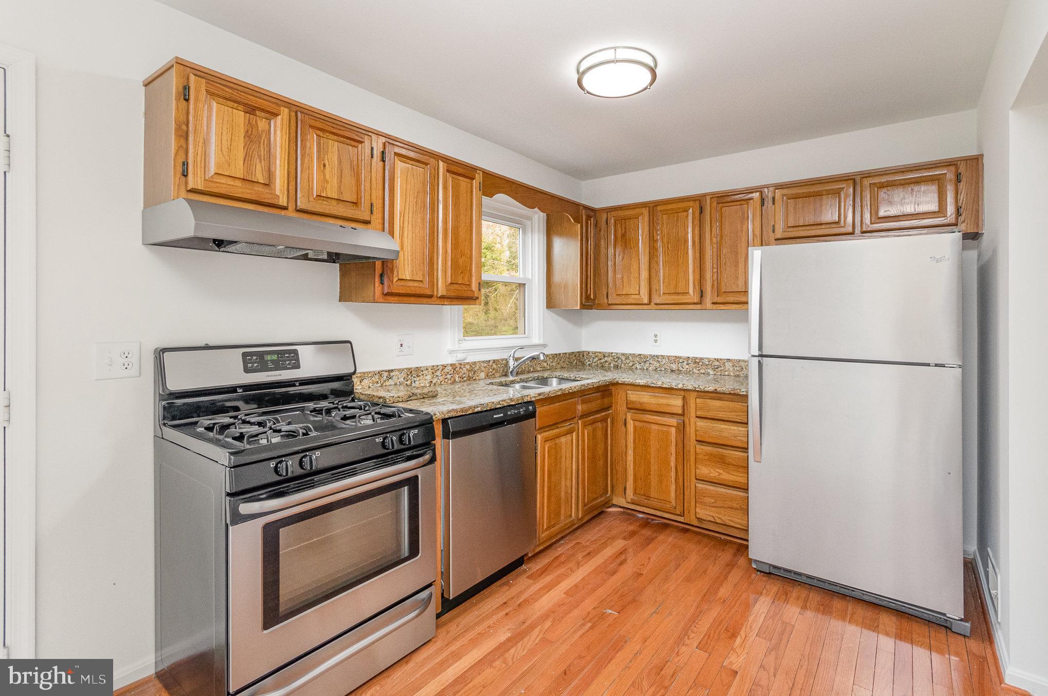 7715 Fort Hunt Road Alexandria, VA 22308 - Photo 7 of 21 a kitchen with granite countertop wooden cabinets and a stove top oven