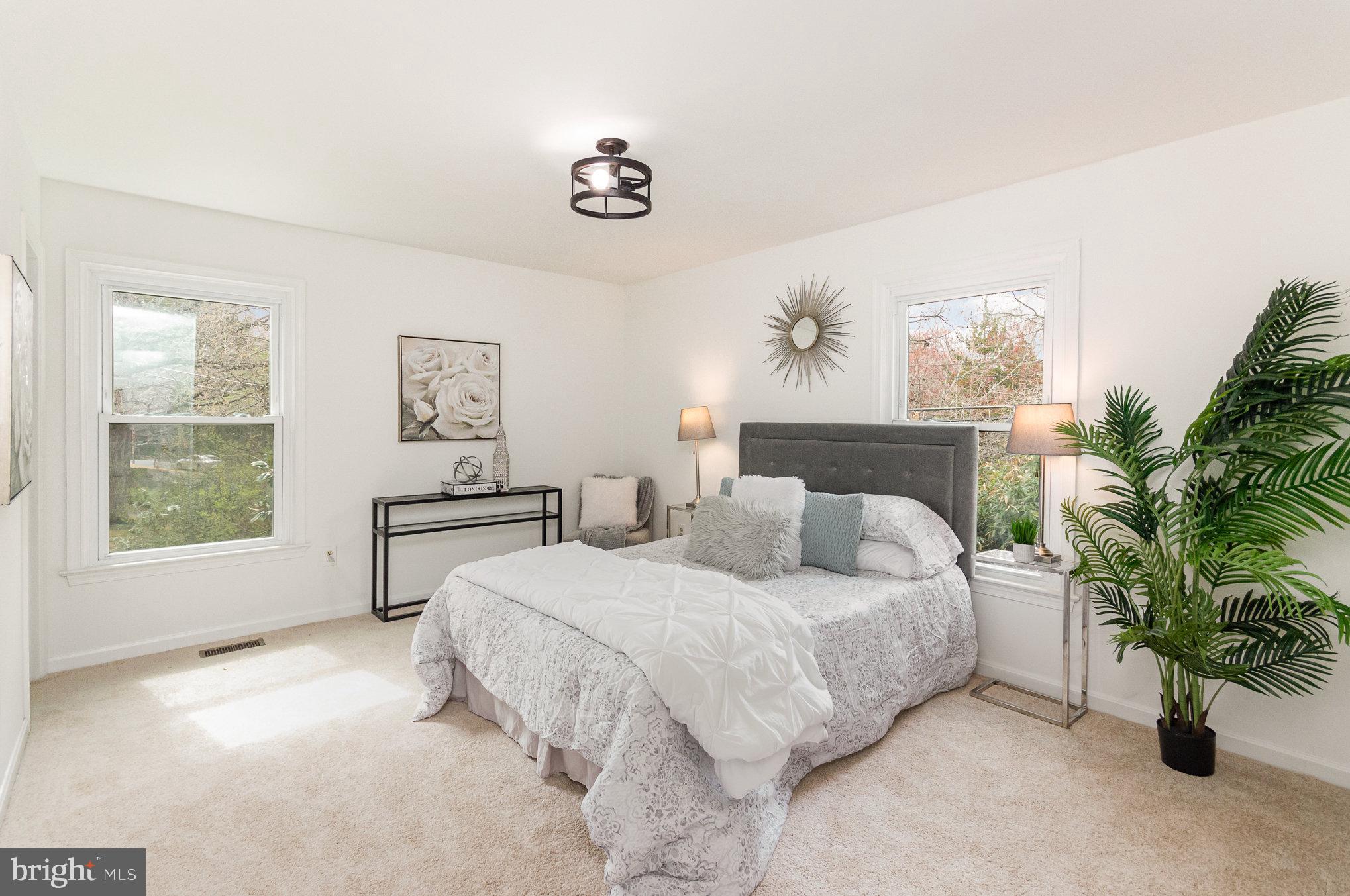 7715 Fort Hunt Road Alexandria, VA 22308 - Photo 10 of 21 a spacious bedroom with a bed a couch and potted plant
