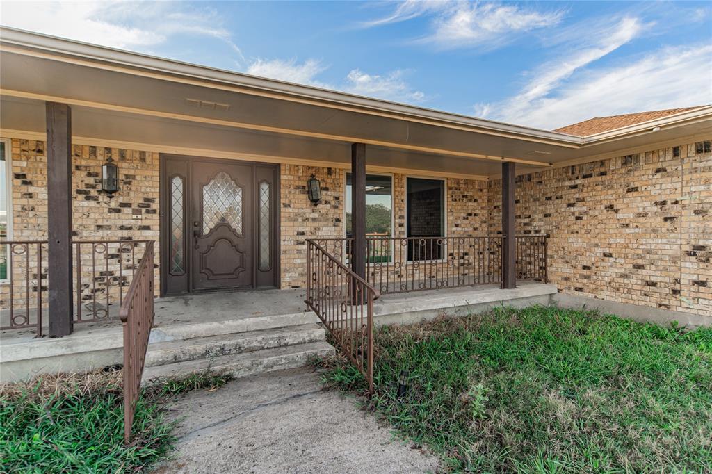 4320 Hickox Road Rowlett, TX 75089 - Photo 3 of 37 Brick facade with a covered entry, double entry doors, decorative glass inserts, and wrought iron railings