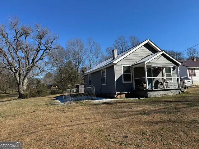a front view of a house with a yard covered in snow