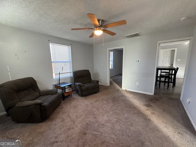 a living room with furniture and a ceiling fan
