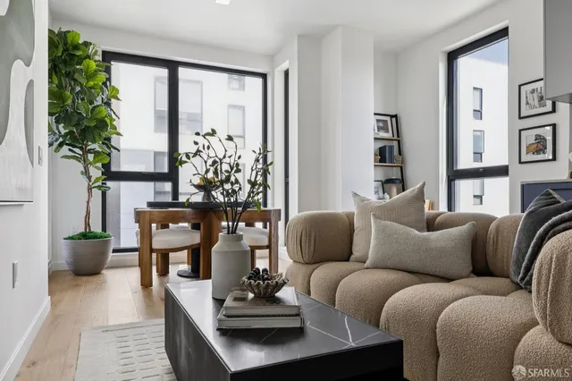 a living room with furniture potted plant and a large window