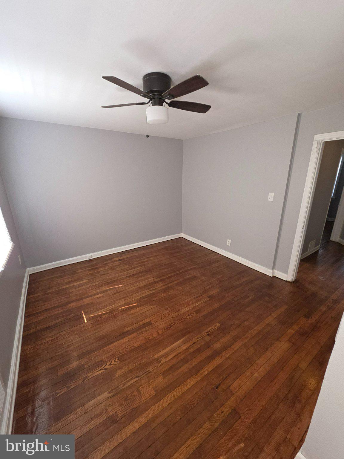 4404 Mountview Road Baltimore, MD 21229 - Photo 8 of 22 an empty room with wooden floor and fan