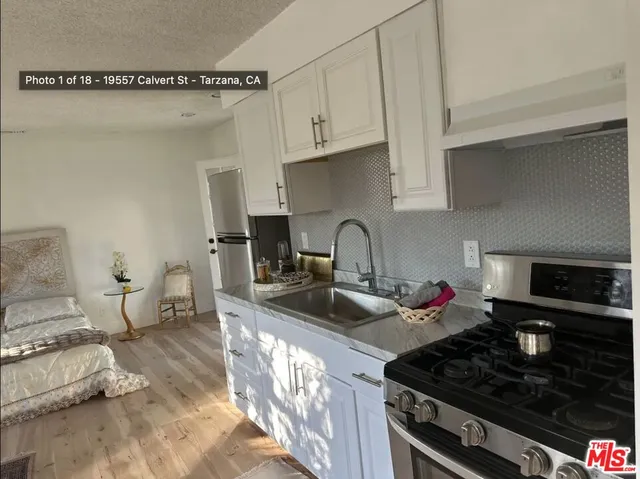 a kitchen with granite countertop a sink stove and cabinets
