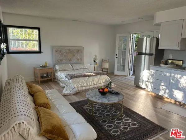 a spacious bedroom with a bed a couch and dresser